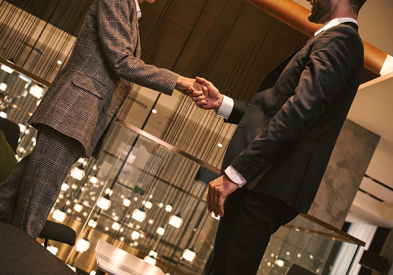 Business meeting of two partners. Man and woman having business lunch at restaurant standing shaking hands businessman smiling friendly