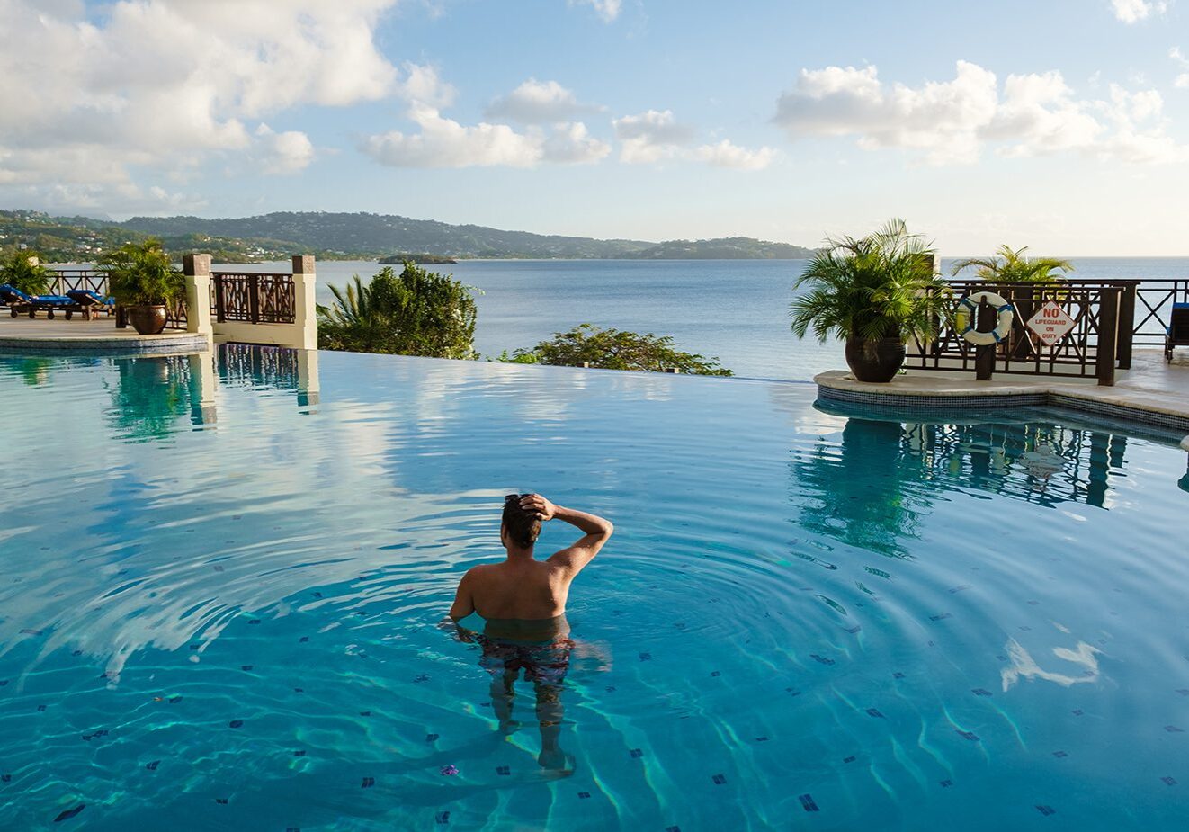 Young men in a swim shorts at Saint Lucia Caribbean, men at infinity pool during sunset. man in a swim short at the pool